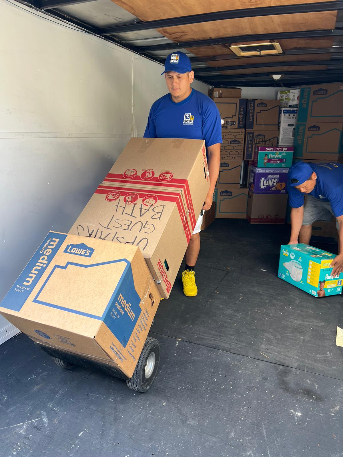Adela & Brothers movers loading a dolly with boxes